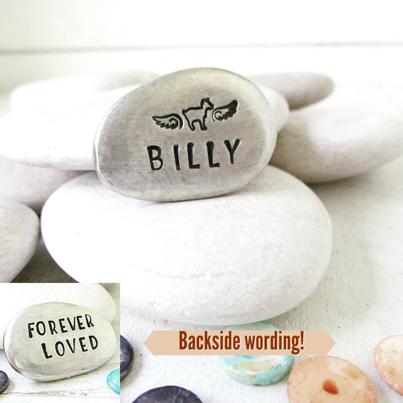 May include: A silver memorial stone with the name "BILLY" engraved on it. A small winged animal is above the name. The back of the stone says "FOREVER LOVED".