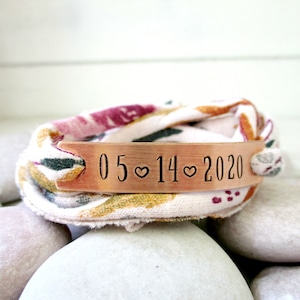 May include: A copper bracelet with a fabric band and the date 05♥14♥2020 engraved on the metal band.