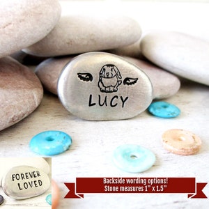 May include: Silver memorial stone with a bunny rabbit engraved on it, with wings and the name Lucy. The stone measures 1 inch by 1.5 inches. The back side of the stone has the words "Forever Loved" engraved on it.
