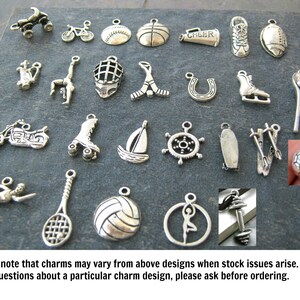 May include: A collection of silver charm pendants featuring various sports and activities, including a basketball, football, sailboat, roller skates, and a motorcycle.  The charms are displayed on a dark gray background.