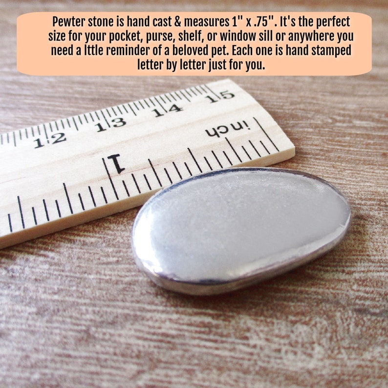 May include: A silver pewter stone measuring 1 inch by 0.75 inches. The stone is next to a wooden ruler with inch markings.