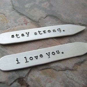 May include: Two silver metal tags with the words "stay strong." and "i love you." engraved on them.