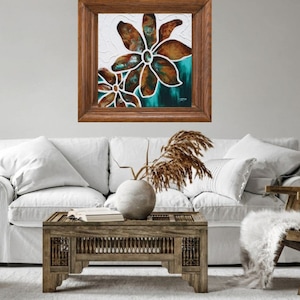 May include: A framed painting of two brown flowers with white outlines on a teal background. The flowers are in a wooden frame.
