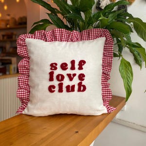 Funda de almohada con volantes de Self Love Club, hecha a mano, con bordado rojo, para decoración de habitación de niña.