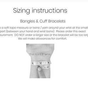 May include: Instructions for measuring wrist size for bangles and cuff bracelets. A black and white illustration shows a hand measuring a wrist with a tape measure. The text reads "This is a 6.5" wrist".