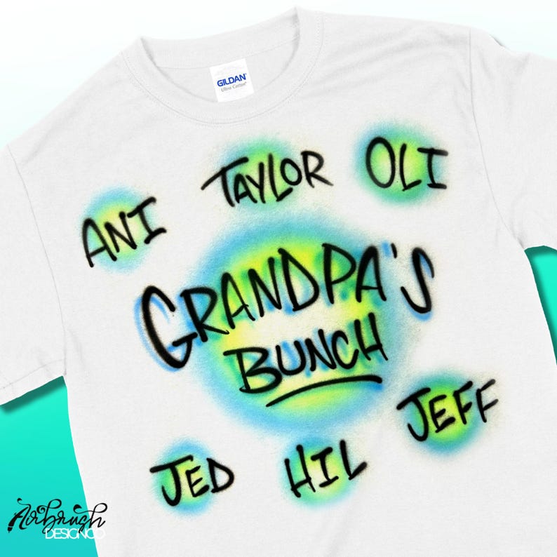 May include: White Gildan t-shirt with airbrushed text. The shirt features the words "Grandpa's Bunch" in the centre, surrounded by names like "Ani," "Taylor," and "Oli." The design includes blue and yellow airbrush effects.