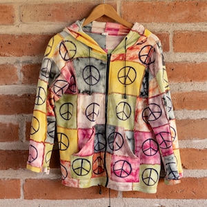 May include: A colorful patchwork hoodie with a zipper closure and a peace sign pattern. The hoodie is made of a soft, comfortable fabric and has a relaxed fit.