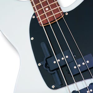 Può includere: Primo piano di un basso elettrico bianco con un battipenna nero e una tastiera in legno. Il basso ha quattro corde e un ponte cromato.