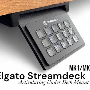 May include: Black Elgato Stream Deck MK1/MK2 Articulating Under Desk Mount. The mount is made of metal and has a black finish. It is designed to hold a Stream Deck and can be adjusted to different angles.