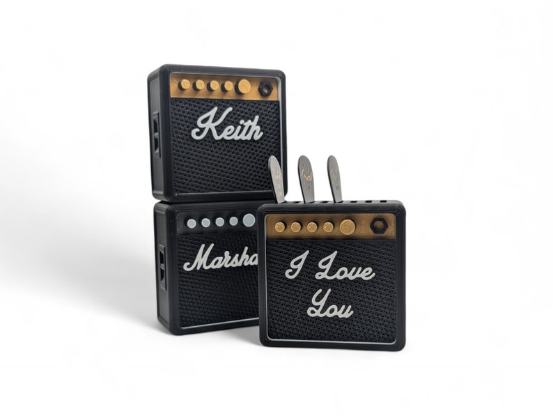 Pu&ograve; includere: Tre mini amplificatori per chitarra neri con dettagli dorati. L'amplificatore superiore ha il nome "Keith" scritto su di esso. L'amplificatore centrale ha il nome "Marsha" scritto su di esso. L'amplificatore inferiore ha le parole "I Love You" scritte su di esso.