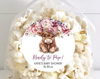 May include: A clear cellophane bag filled with popcorn, tied with a white ribbon. A round sticker on the bag features a watercolor illustration of a Highland cow with a floral crown and the text "Ready to Pop!" and "Katie's Baby Shower 10.30.xx".