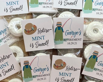 May include: Small clear plastic bags containing white mint candies, each with a printed square tag. The tags feature a fishing-themed illustration and the text "Retire - MINT is Sweet!" and "George's RETIREMENT 10.29.21".