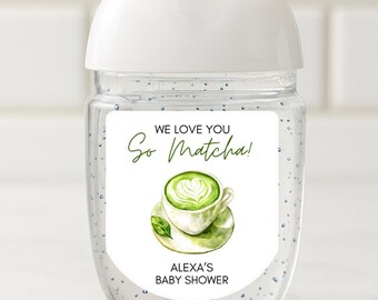 May include: A clear hand sanitizer bottle with a white cap. The label reads "We Love You So Matcha!" with a watercolor illustration of a matcha latte. The text "Alexa's Baby Shower" is below the illustration.