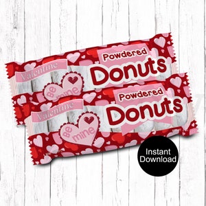 May include: Two identical rectangular packages of powdered donuts featuring a red background with pink and red hearts. The text reads Valentine, Powdered Donuts, and Be mine inside a heart shape. A black circle contains the text Instant Download.