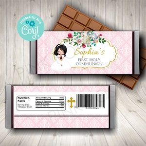 Puede incluir: Envoltorio de barra de chocolate rosa y blanco con un diseño floral y una niña con un vestido blanco. El envoltorio dice "Sophia's First Holy Communion".