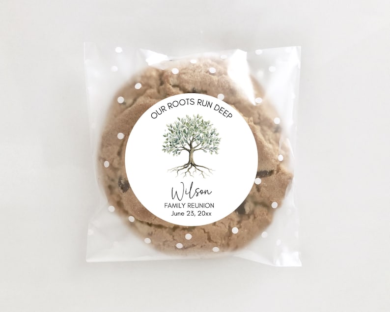 May include: A chocolate chip cookie in a clear cellophane bag with white polka dots. A round sticker on the cookie reads "OUR ROOTS RUN DEEP" with a tree illustration and the name "Wilson" and "FAMILY REUNION June 23, 20xx."