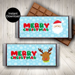 May include: Two chocolate bar wrappers with a light blue background and white snowflakes. The wrappers say "MERRY CHRISTMAS" in red and green. One wrapper has Santa Claus, the other has a reindeer.