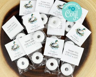 May include: A set of 10 baby shower favors featuring a watercolor illustration of a duck. Each favor includes a small round mint in a clear cellophane bag with a tag that reads "Thank you for coming. It mint a lot!" and "Emily's Baby Shower 4.24.xx".