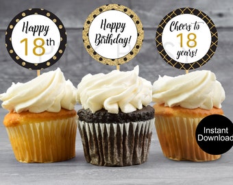 May include: Three cupcakes with black and gold 18th birthday cupcake toppers. The toppers say "Happy 18th", "Happy Birthday!" and "Cheers to 18 years!"