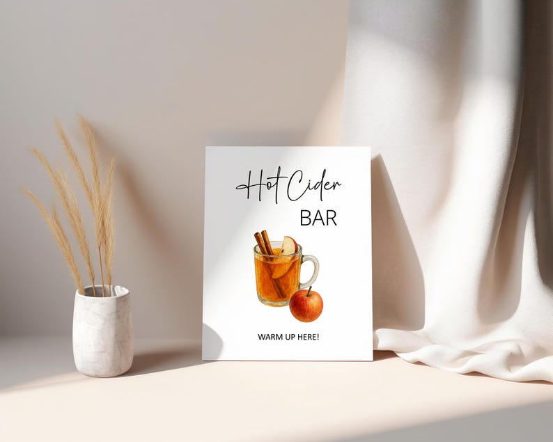 May include: A white sign with the words "Hot Cider BAR" in black script, and a watercolor illustration of a hot cider drink with cinnamon sticks and an apple. The sign also says "WARM UP HERE!" in black text.