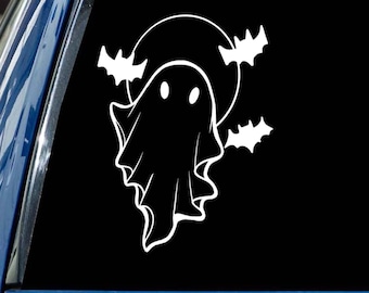 May include: White vinyl decal featuring a cartoon ghost with two oval eyes, a circular moon, and three bats. The design is set against a black background, creating a spooky Halloween theme.