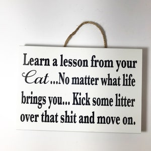 Funny cat sign.  Learn a lesson from your cat ... no matter what life brings you ... kick some litter over that shit and move on