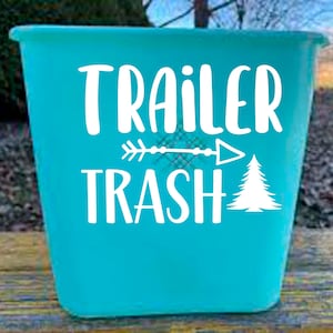 May include: A turquoise blue plastic bin with a white vinyl decal that says "TRAILER TRASH" with an arrow pointing to the right and a small pine tree graphic.