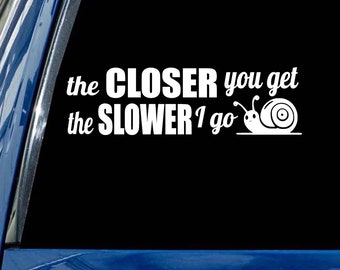 May include: White vinyl decal with the text "the CLOSER you get the SLOWER I go" and a cartoon snail illustration.
