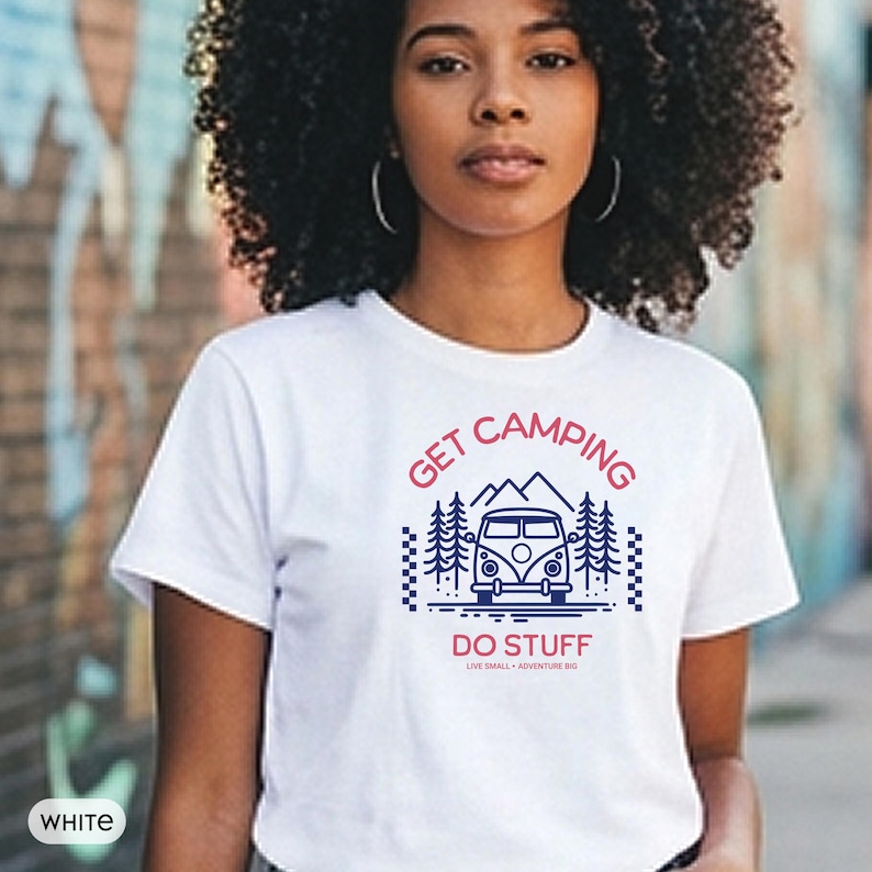 Pode incluir: Uma t-shirt branca de manga curta com uma impress&atilde;o gr&aacute;fica de uma carrinha de campismo, pinheiros e montanhas. O texto GET CAMPING DO STUFF e LIVE SMALL - ADVENTURE BIG est&aacute; impresso em tinta vermelha e azul escura no peito.