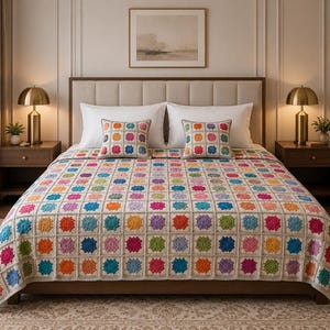 May include: A crochet bedspread and two matching square throw pillows featuring a repeating granny square pattern. Each square consists of a vibrant, multi-colored floral center in shades of pink, orange, yellow, green, and blue, framed by beige yarn.