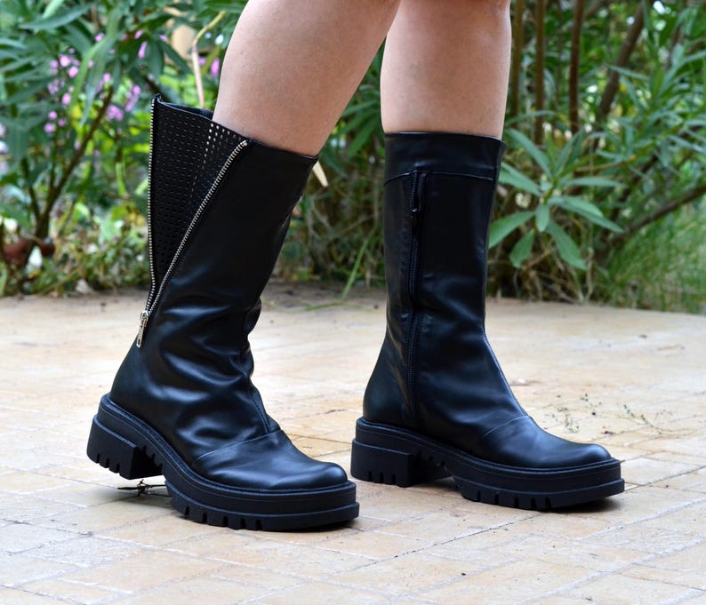 K&ouml;nnte beinhalten: Schwarze Lederstiefel mit seitlichem Rei&szlig;verschluss und einer dicken Plateau-Sohle.