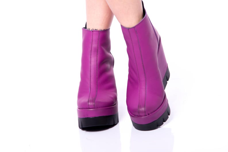 May include: A pair of purple platform boots with a pointed toe and a thick heel.