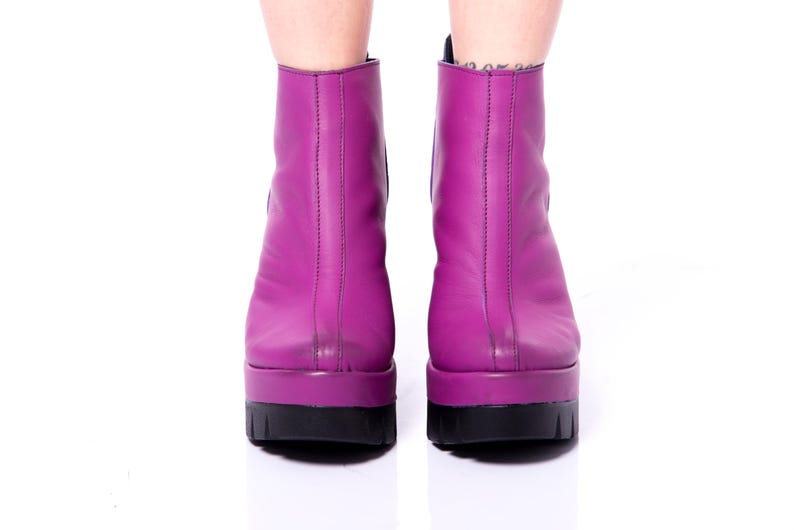 May include: A pair of purple platform ankle boots with a black sole.