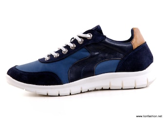 May include: Blue and navy blue sneakers with white laces and a white sole. The sneakers have a suede and leather upper.