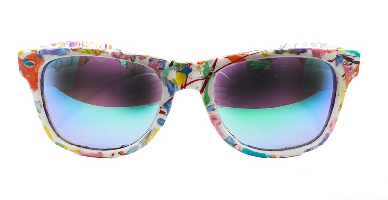Puede incluir: Gafas de sol blancas con montura con estampado floral colorido. Las lentes tienen un efecto degradado, pasando del morado al azul y al verde. Un accesorio vibrante.