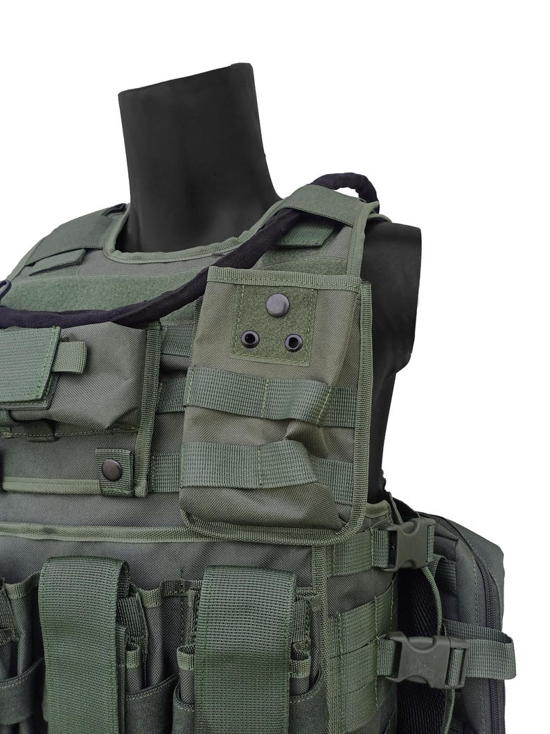 May include: Olive green tactical vest with multiple pouches, straps, and a black neck support. The vest features various compartments and adjustable straps for a secure fit. The design suggests a focus on functionality and durability.