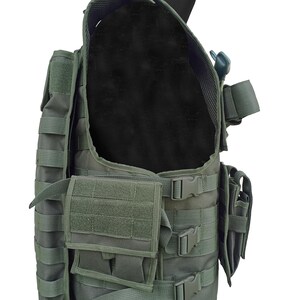 May include: Olive green tactical vest with multiple pouches, straps, and buckles. The vest has a modular design with a black interior lining. It features adjustable straps and various attachment points for gear.