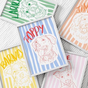 May include: Five framed rectangular prints featuring line art illustrations of dogs. Each print displays a dog's face over a vertical striped background in pastel colours, with the dog's name written in a bold, matching colour script font.