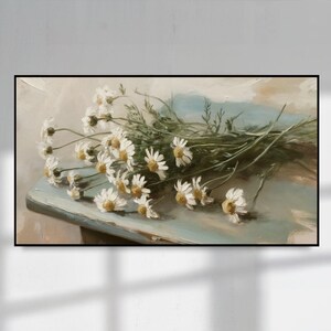 Könnte beinhalten: Ein Ölgemälde zeigt einen Strauß weißer Gänseblümchen mit gelben Zentren und grünen Stielen. Die Blumen sind auf einer hellblauen Oberfläche angeordnet, mit einem weichen, verschwommenen Hintergrund aus Beige- und Blautönen. Das Kunstwerk hat einen Vintage-Stil.