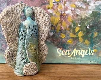 Glazed Ceramic Sea Angel with "Love & Light" message on the backside. Includes led tea light adding sparkle through the holes.