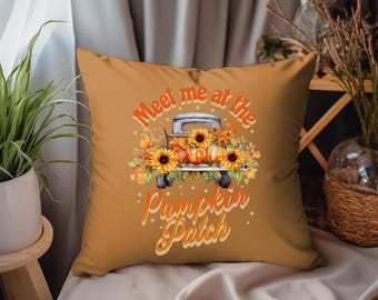 May include: A brown throw pillow with the text "Meet me at the Pumpkin Patch" in a retro font. A vintage truck with pumpkins and sunflowers is pictured in the centre of the pillow.