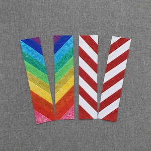 May include: Four fabric strips for quilting, two with rainbow chevron patterns, and two with red and white chevron patterns.