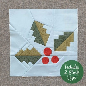 May include: A quilt block pattern featuring a geometric design with green, brown, and white fabric. The block also includes red circles. The text "Includes 2 Block Sizes" is written in green on a white circle.