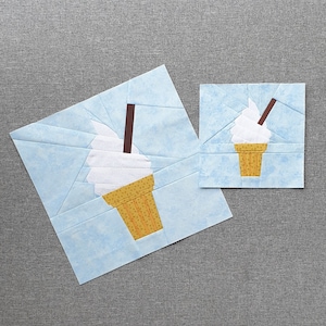 Könnte beinhalten: Zwei Papier-Applikationen von Eisbechern auf blauem Hintergrund. Der größere Becher ist weiß mit einem braunen Stiel und einem gelben und orangenen Kegel. Der kleinere Becher ist weiß mit einem braunen Stiel und einem gelben und orangenen Kegel.