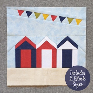 May include: A quilt block pattern featuring three beach huts with red, white and blue stripes. The huts are set against a light blue sky with a yellow, red and green bunting above. The text "Includes 2 Block Sizes" is in a circle at the bottom right.
