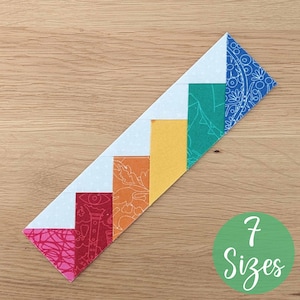 May include: A colorful fabric strip with a stair-step design, featuring red, orange, yellow, green, and blue patterned sections. The design includes white sections and a blue paisley patterned end. A green circle with the text "7 Sizes" is in the image.