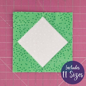May include: A square fabric block with a white diamond shape in the center, surrounded by green fabric with small white polka dots. The block is on a pink cutting mat. A purple circle with the text "Includes 11 Sizes" is in the lower right corner.