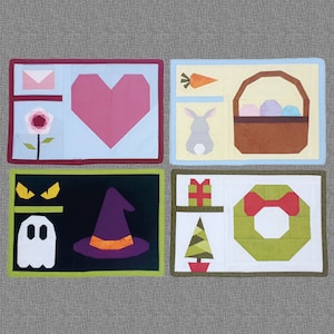 May include: Four colorful square cards with different designs. The first card has a pink heart, a flower, and a letter. The second card has a carrot, a bunny, and a basket of eggs. The third card has a ghost, a witch's hat, and two eyes. The fourth card has a gift, a Christmas tree, and a wreath.