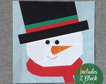 May include: A paper pieced snowman block pattern with a black top hat, red scarf, and orange nose. The pattern includes two block sizes.
