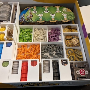 May include: White plastic organizer insert for a board game box. The insert has compartments for storing game pieces, cards, and tokens. The insert is designed to fit the game "The Land of  Kizmit".